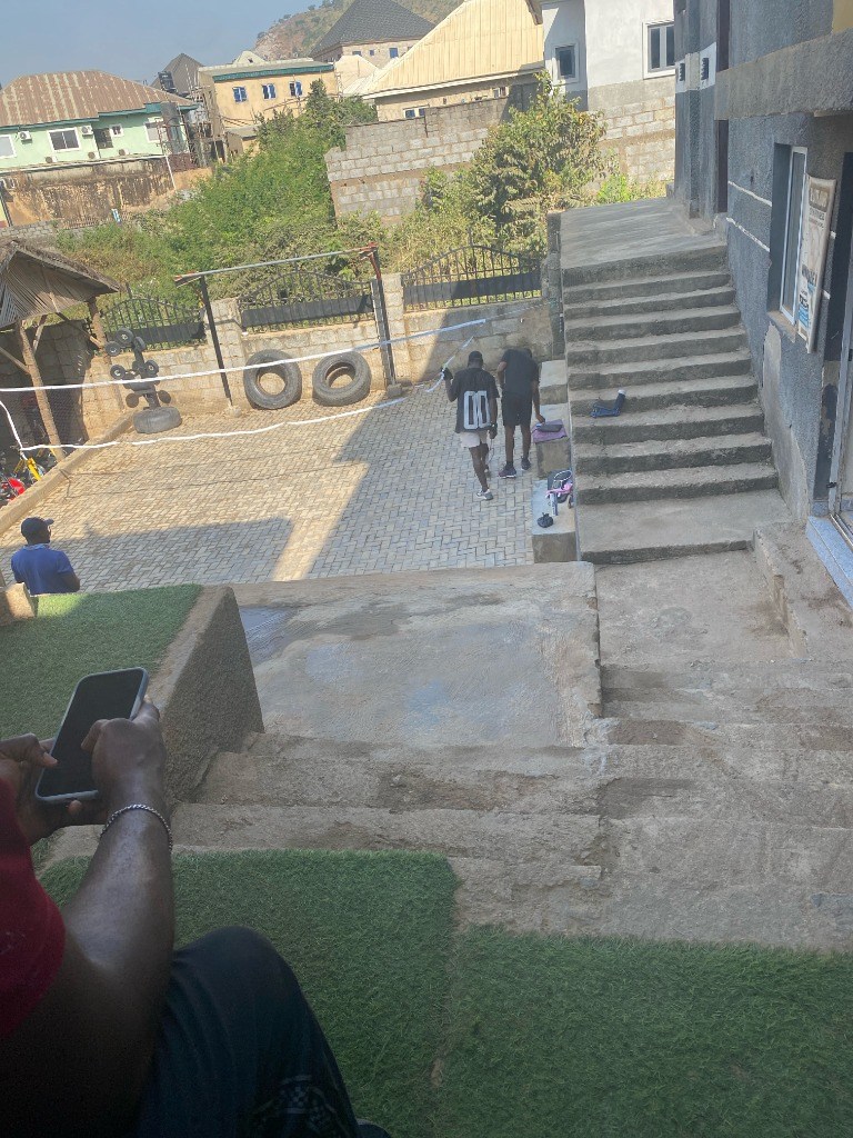 Outdoor conditioning courtyard at G:Lite Hub with badminton net, conditioning steps, and tire training