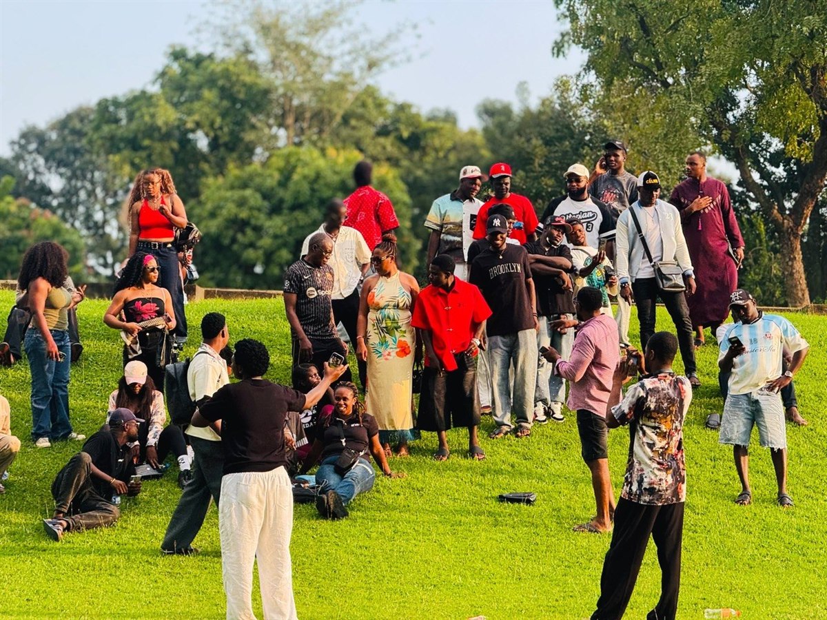 Gym members socializing and relaxing on the green lawn after workout